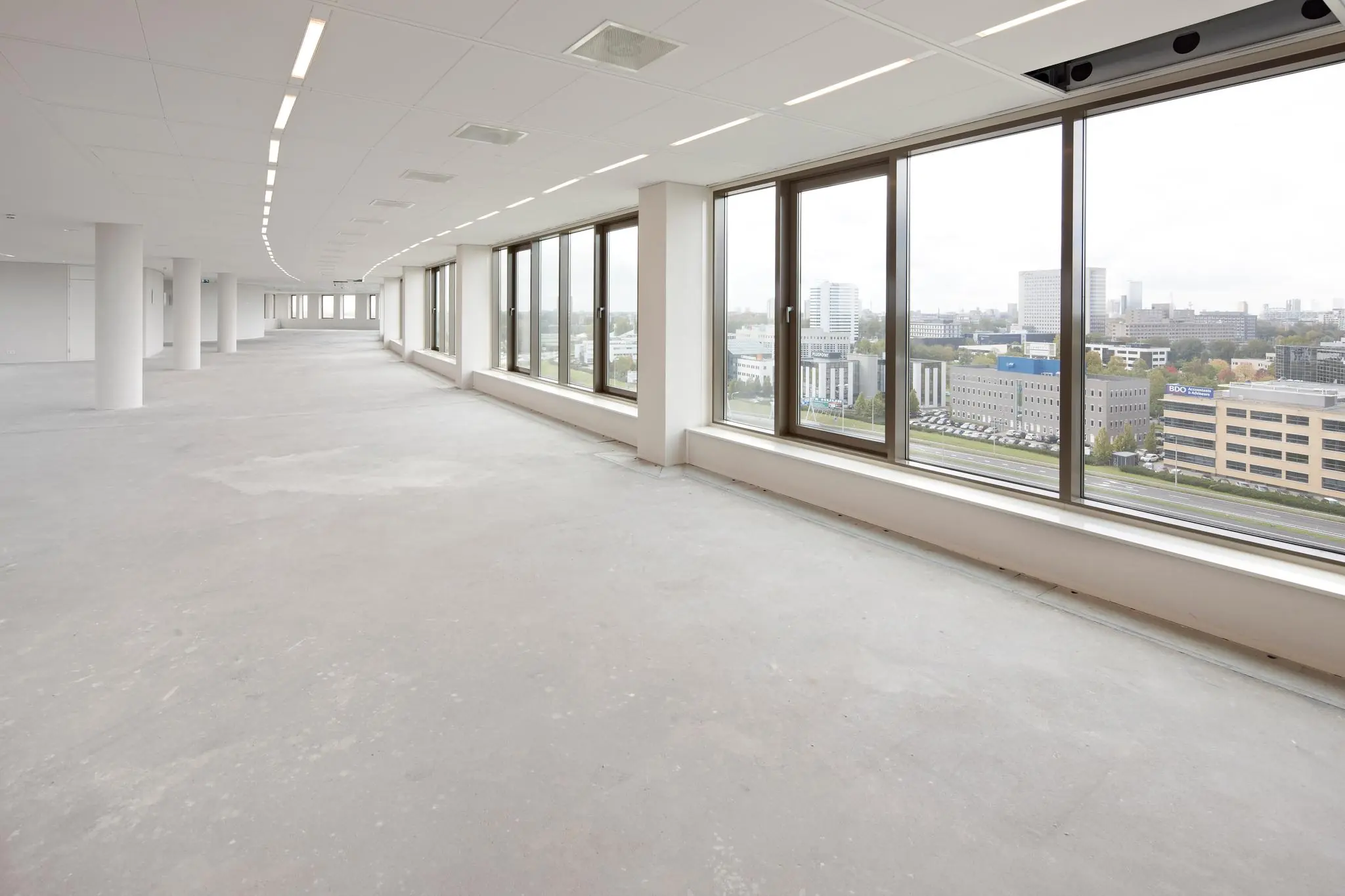 Lichte, lege kantoorruimte aan de Fascinatio Boulevard met grote ramen en uitzicht op een modern zakendistrict.